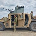 Наёмник на фоне американской бронированной HMMWV (Humvee) в зоне проведения СВО.